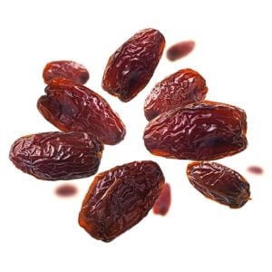 Dried dates levitate on a white background.